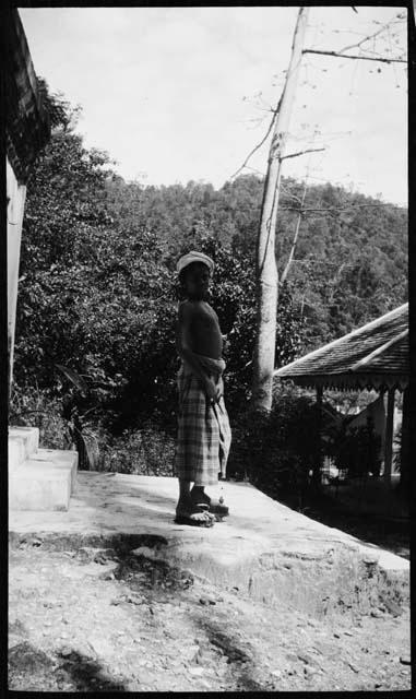 Child standing on a platform in front of a building