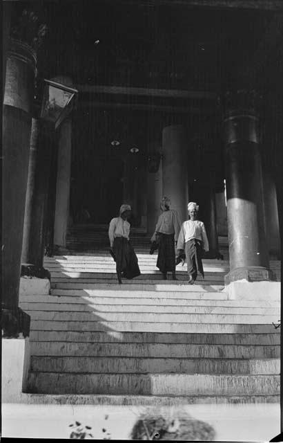 Three men walking down stairs