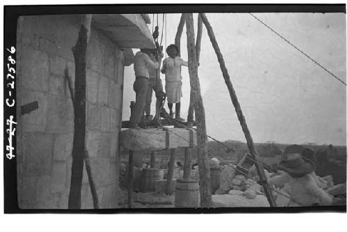 Caracol. Raising stone block for restoration in 5-member cornice.