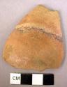 Ceramic body sherd, orange ware with faint black glaze stripe, rounded profile