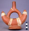 Ceramic complete bottle, stirrup spout, crescent shaped body w/foot, buff/red