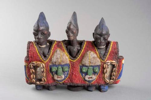 An engraved and carved sculpture depicting Ibeji triplet figures