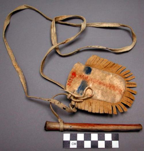 Pubescent girl's paint pouch of buckskin, fringed. Bone drinking tube attached.