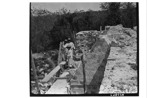 Laborers repairing arched roof at Temple of Three Lintels.