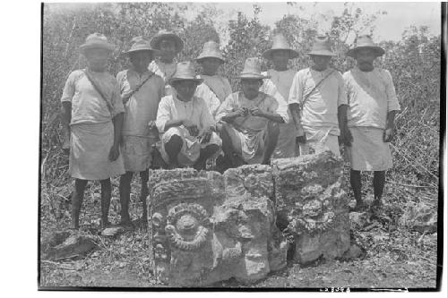 People standing around Tlaloc carved altar in milpa