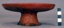 Restored red shallow pedestal-base pottery vessel