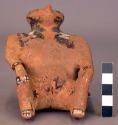 Ceramic figurine, seated human, polychrome, paint flaking