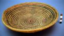Small basket tray. Made of bear grass. Geometric designs in black, brown, blue