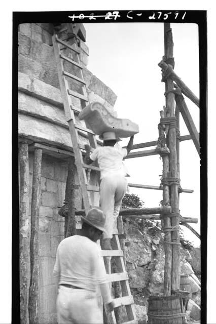 Caracol. Native carrying stone nose up ladder for restoration in mask panel over