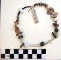 Small necklace of irregularly shaped purple wampum green rock and white shell