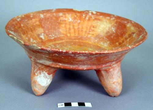 Ceramic tripod plate, red on orange, legs perforated, chipped rim