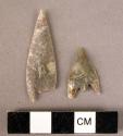 2 flint arrowheads: 1 long with short tang and long barbs; 1 lance-like with rud