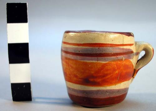 Miniature pottery cup -- pink, orange and red on buff