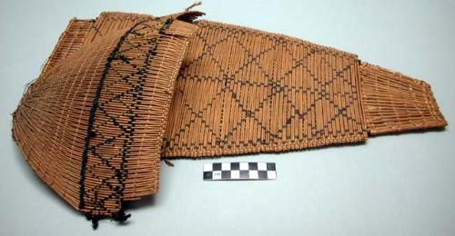 Paiute toy cradleboard. Made from wicker w/ some dark design elements.