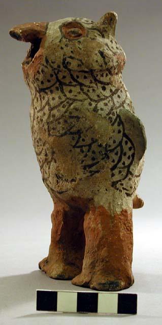 Owl like clay figure with black and white designs, broken beak.