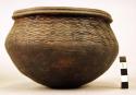 Ceramic bowl, rounded base, grooved rim, incised wavy design around body