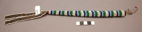 Plains needle or awl case. Wrapped with beads, decorated with streamers.