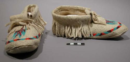 Pair of white moosehide moccasins with orange, red and turquoise glass bead deco