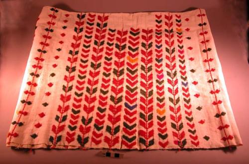 Huipil. white background with red, green, and orange embroidery. 94 x 46 cm.