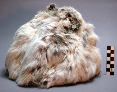 Winter cap of white hare skin (double). Heads and feet of hares meet at crown.