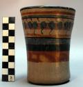 Cup. Greyish slip, polished on exterior only,  rust, blue and black design.