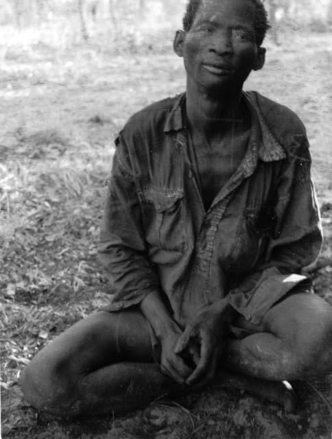 Tango or /Hish (husband of !Aikwe) wearing a shirt, sitting