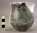 Ceramic jar, black burnished, round body flat base, heavily reconstructed