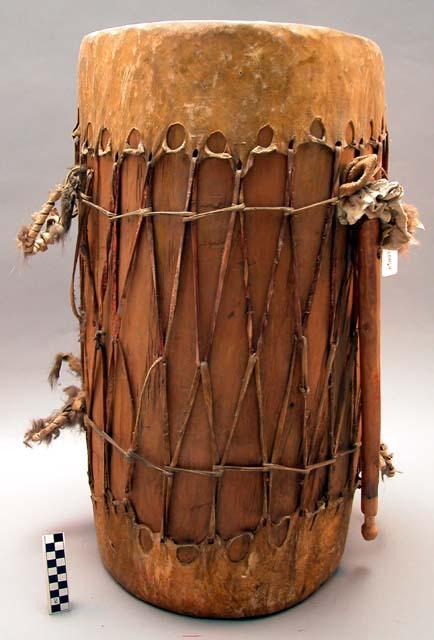 Drum and stick. Hollow log - skin covering wood stick.