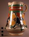 Majolica ware pitcher with stylized floral design in orange, brown, green, blue,