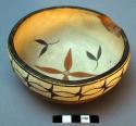 Corn pollen bowl with red glazed exterior and painted interior. Geometric patte