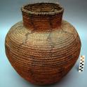 Storage basket. 3 rod coiled. Reddish brown designs of human and animal