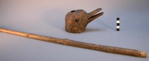 Wooden tobacco pipe; bowl in form of a duck's head with button eyes. Long stem.