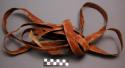 Flat rawhide strap used as a halter or neck rope for horses, painted red.