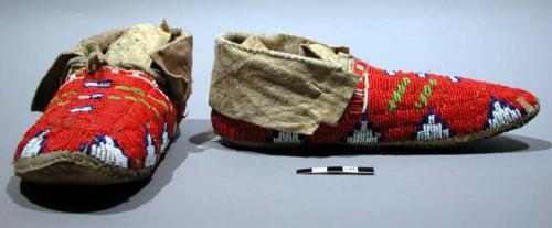 Skin moccasins with orange-red bead background