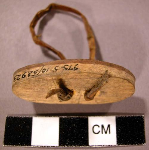 Small wooden lid? With gut or sinew fastening (oval shape). 4 cm. l., 2 cm. w.