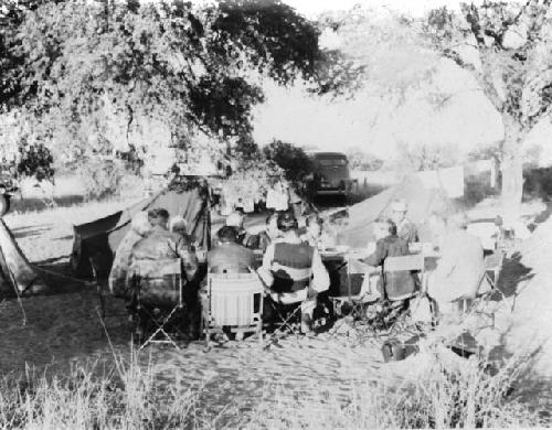 Expedition members sitting around a table in the camp