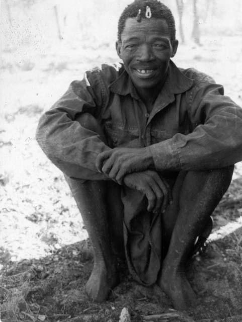 Mishi (husband of /Ao or Bambi, and brother of Mushulay or Moãshay) wearing a shirt, sitting