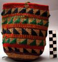 Cornhusk bag. Cylindrical shape. Rows of linear and triangular designs in yarn