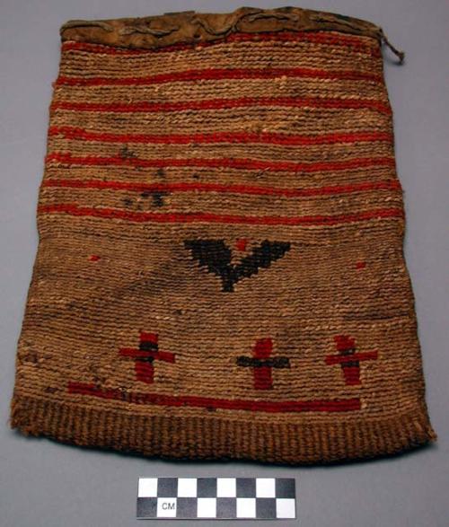 Cornhusk bag. Leather sewn around opening. Designs in red yarn on both sides