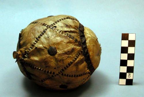 Skin ball stuffed with grass, decorated with diamond and circle patterns.