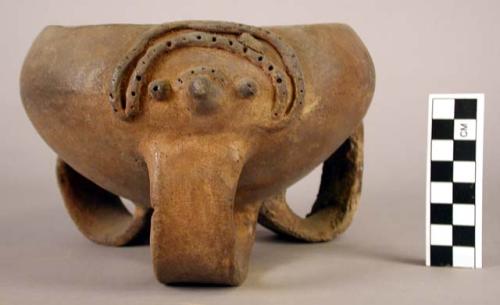 Unpainted pottery bowl with 3 band legs and relief decoration in form of face