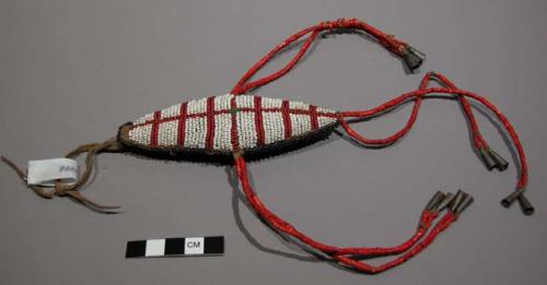 Sioux umbilical amulet. Roughly diamond-shaped hide covered w/ beads. Design dif