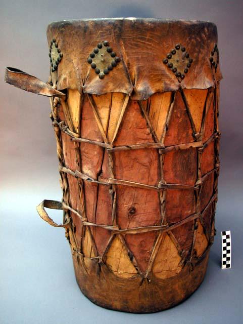 Wooden drum - top, bottom & tighteners of hide; squares of lighter hide attached