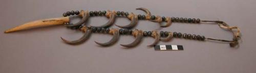 Sioux necklace. Strung w/ eagle claws and faceted black beads on buckskin. Carve