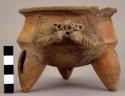 Tripod pottery bowl with carinated profile, handles. Outcurving rim decorated wi