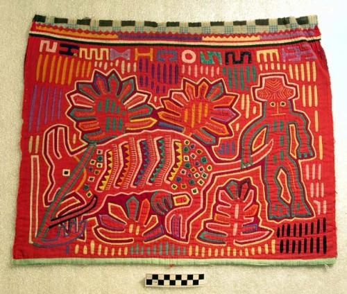 One of a pair of matching molas primarily red, each depicting a man, a horned an