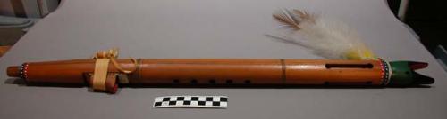 Wood flute with bird beak motif. decorated with red, white, blue and green pain