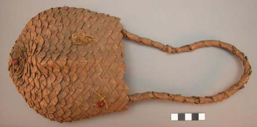 Pouch-like basket - decorated with 3 red seeds (?) and handle