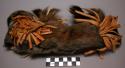 Narrow headband of cased squirrel skin ornamented with rosettes or bows of cut buckskin painted red.