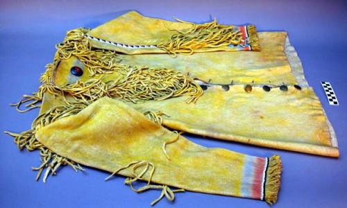 Buckskin shirt-coat. Made of yellow dyed leather. Fringed with metal buttons.